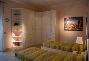 a bedroom with two beds and a closet at Solimena House in Nocera Inferiore