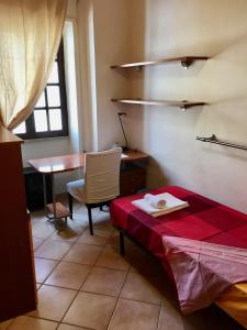 een kamer met een tafel, een bed en een bureau bij Casa Delfino - Appartamento Centro Storico a due passi dalla Spiaggia & Mare, Porto & Ferrovia in Civitavecchia +37 foto's