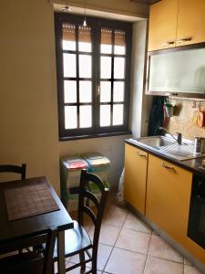 een keuken met een tafel, een wastafel en een raam bij Casa Delfino - Appartamento Centro Storico a due passi dalla Spiaggia & Mare, Porto & Ferrovia in Civitavecchia