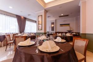 un comedor con mesas y sillas con sombreros en Europa Palace Hotel, en Messina