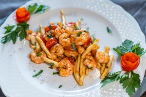 un plato de camarones y pasta en un plato blanco en Europa Palace Hotel, en Messina