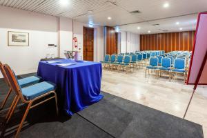 a conference room with a blue table and chairs at Europa Palace Hotel in Messina