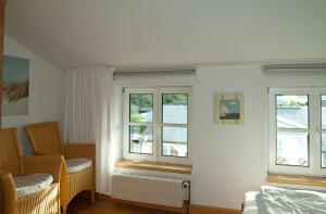 ein Schlafzimmer mit zwei Fenstern, einem Stuhl und einem Heizkörper in der Unterkunft Wohnung 5 Haus Borgwardt in Göhren