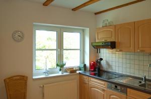eine Küche mit Spüle und Fenster in der Unterkunft Wohnung 5 Haus Borgwardt in Göhren