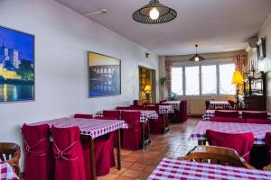 アヴィニョンにあるオ サン ロク - ホテル エ ジャルダンの赤と白のテーブルと椅子が備わるレストラン