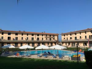 un hotel con una piscina con sillas y sombrillas en Aurelia Rta Detta il Cascinale, en Montignoso
