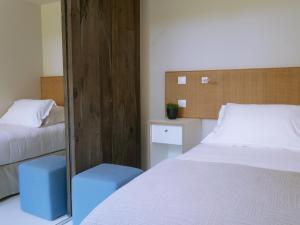 a small bedroom with two beds and a mirror at La Plage Casadelmar in Porto-Vecchio