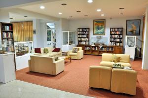 una sala de estar con sofás y sillas en una biblioteca. en Valais Hotel, en Alikanas