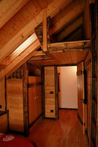 an attic room with a bed and a wooden ceiling at Chalet Al Cucù in Ovaro