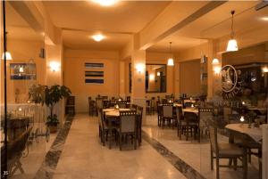 a dining room with tables and chairs in a restaurant at Hotel Akti Arilla in Arillas