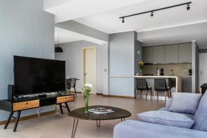 uma sala de estar com uma televisão, um sofá e uma mesa em New Modern City View Apartment - PH Quartier Del Mar na Cidade do Panamá