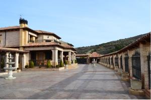 an empty courtyard of a building with a mountain in the background at Hostal Rural & Spa Las Vistas in Pastrana