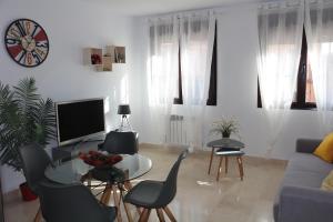 uma sala de estar com uma mesa e cadeiras e uma televisão em Apartamento Homelife Roca Tarpeya 4 em Toledo