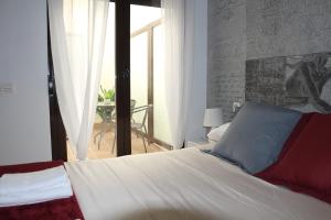 a bedroom with a large bed and a balcony at Apartamento Homelife Roca Tarpeya 4 in Toledo