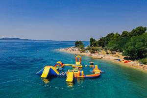 a group of inflatable slides in the water on a beach at Luxury Villa Nada with Pool in Petrcane