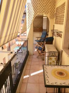 een balkon met stoelen en een tafel in een gebouw bij Casa Delfino - Appartamento Centro Storico a due passi dalla Spiaggia & Mare, Porto & Ferrovia in Civitavecchia