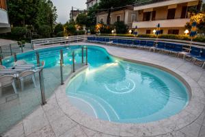 - une piscine d'eau bleue dans un bâtiment dans l'établissement Hotel Torretta, à Cattolica