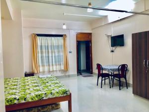 a bedroom with a bed and a table and a television at Pine Hill Home Stay in Shillong