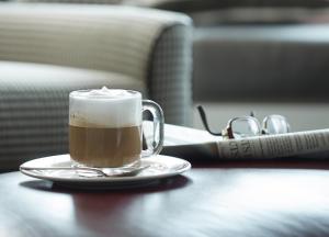 eine Tasse Kaffee auf einem Tisch mit einem Buch in der Unterkunft Hotel Commonwealth in Boston