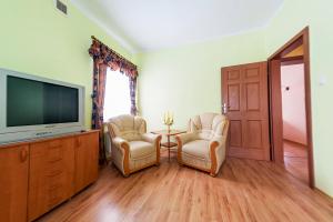sala de estar con 2 sillas y TV de pantalla plana en Uroczysko, en Jastrowie