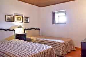 zwei Betten in einem Zimmer mit Fenster in der Unterkunft Casa da Quinta do Cruzeiro in Fontoura
