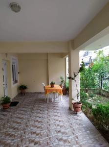 a table and chairs on a patio with plants at Nice and cosy house 2 in Larisa