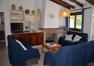 een woonkamer met 2 blauwe stoelen en een open haard bij Finca típica mallorquina CAN PUÇA in Santanyi