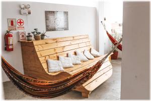 a large wooden hammock with pillows in a room at ATMA Hostel & Yoga in Huanchaco