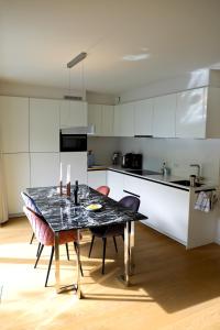 una cucina con tavolo, sedie e bancone di Modern Appartment in the Heart of Ghent a Gand