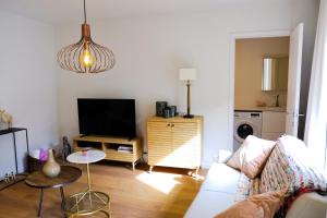 a living room with a couch and a tv at Modern Appartment in the Heart of Ghent in Ghent