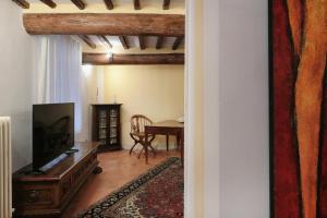 a living room with a television and a table at Suite Testamatta in Pisa