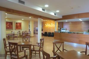 a restaurant with tables and chairs and a bar at La Cañada in Horche