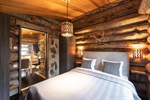 a bedroom in a log cabin with a bed and a mirror at UnelmaKanerva in Ruka