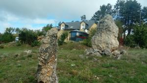 dos rocas grandes en un campo frente a una casa en Chez Louis chambres d'hôtes à la ferme, en La Canourgue