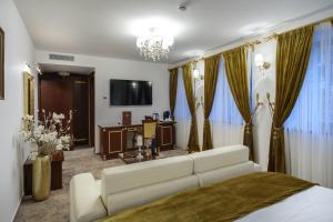 ein Wohnzimmer mit einem weißen Sofa und einem TV in der Unterkunft Integra Hotel in Trebinje