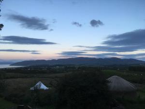 a view of a field with mountains and a sky at Portsalon Luxury Camping in Portsalon