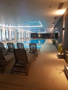basen w hotelu z krzesłami w holu w obiekcie Apartament Bałtyk Nadmorskie Tarasy z parkingiem w Kołobrzegu