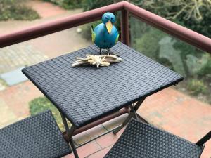 un pájaro azul sentado sobre una mesa en Ferienwohnung Stadtlust II direkt am Husumer Hafen, en Husum