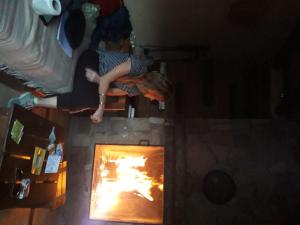 una mujer parada frente a un horno de fuego en Cabañas Hoja de la Tierra en Chascomús
