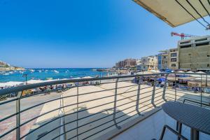 a balcony with a view of a beach and the ocean at Marsalforn Apartment Del Mar in Marsalforn