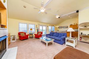 a living room with a blue couch and red chairs at Swink Cottage in Southern Shores