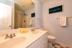 a bathroom with a sink and a toilet and a mirror at Swink Cottage in Southern Shores +42 photos