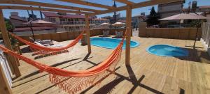 a hammock on a deck next to a pool at Pousada Milani in Florianópolis