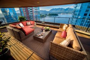 balcón con sofá, sillas y mesa en Pinnacle Hotel Harbourfront en Vancouver