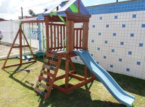a wooden playset with a slide in a yard at Praia do Frances in Praia do Frances