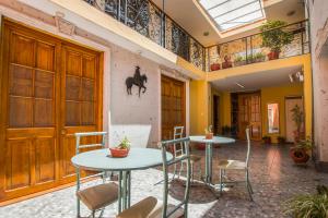 una habitación con 2 mesas y sillas y un caballo en la pared en Villa Sillar, en Arequipa