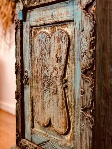 an old wooden door with a butterfly design on it at Cala Bassa Beachhouse in Noordwijk aan Zee