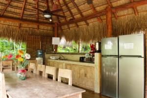 a kitchen with a table and a refrigerator at Joy Tulum - Adults Only. in Tulum