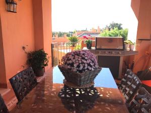 a table with a basket of flowers on a balcony at Marbella Deluxe Rooms in Royal Cabopino Townhouse in Marbella