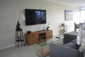 a living room with a couch and a tv at 71 Sea Lodge Beachfront Apartment in Durban